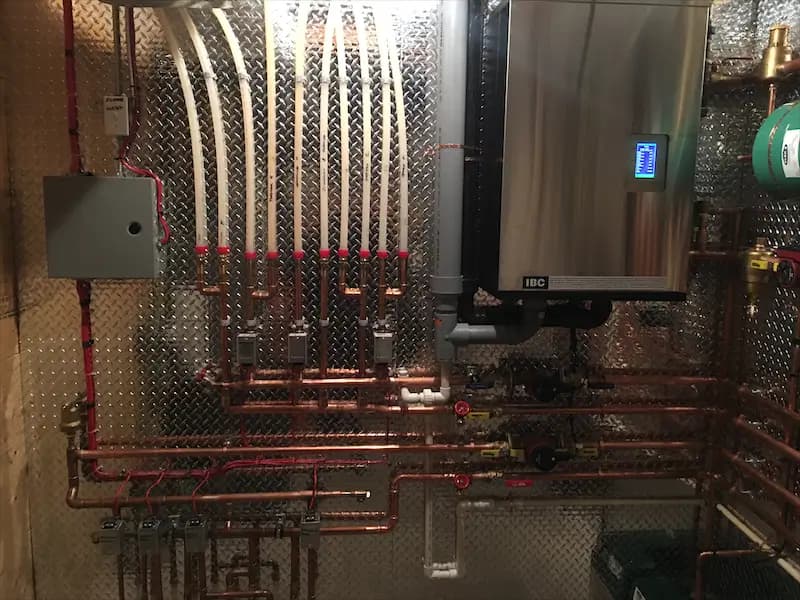 FlameTech technician repairing a boiler in an Airdrie home